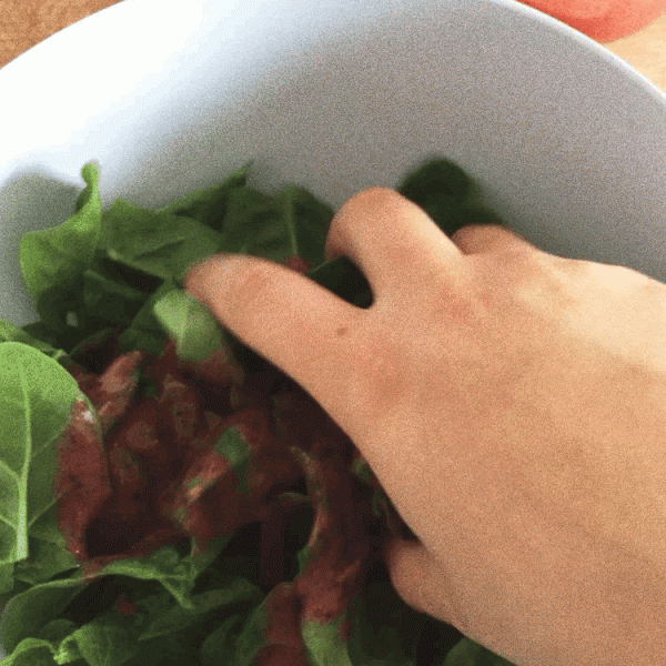 Mixing spinach with strawberry sauce